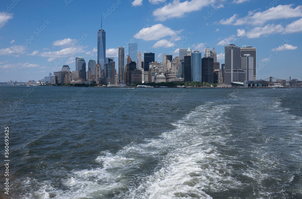 Skyline of downtown manhattan New York during daytime as seen from a boat. Space for text on water.