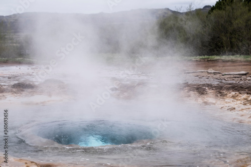 Strokkur geyser in Iceland a fraction of a second before the eruption with boiling hot water