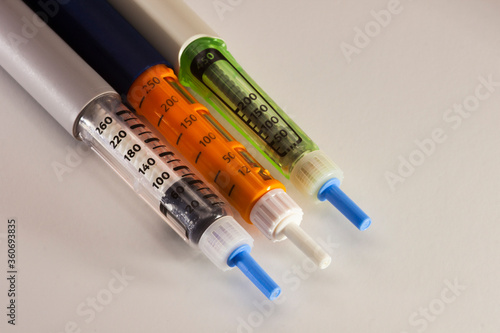 Diabetic insulin syringe injectors, injector pen. Three syringe-pen for diabetic patient on white background photo