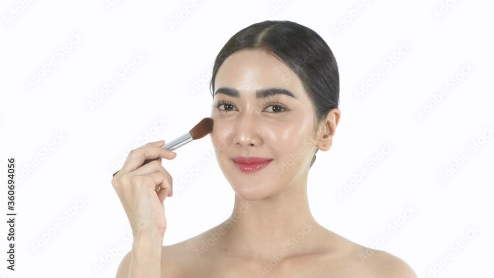 Beauty concept. An Asian woman is makeup with a brush. 4k Resolution.