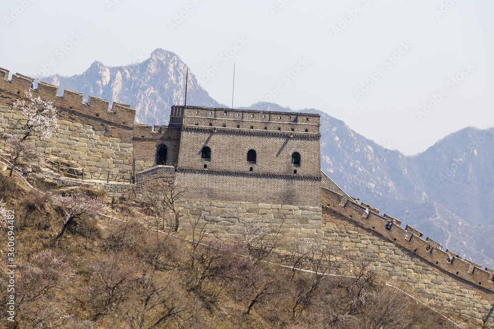 Fototapeta premium Beijing, China - CIRCA 2020: Great Wall of China in a green forest landscape at Mutianyu in Huairou District near Beijing, China. Autumn view of Grate Wall of China