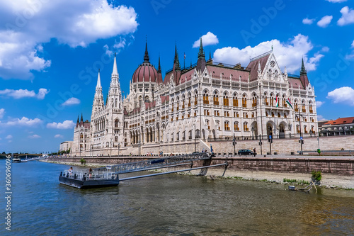 A view of the east bank of the River Danube in Budapest towards the Parliament Building and ferry boat jetty during summertime