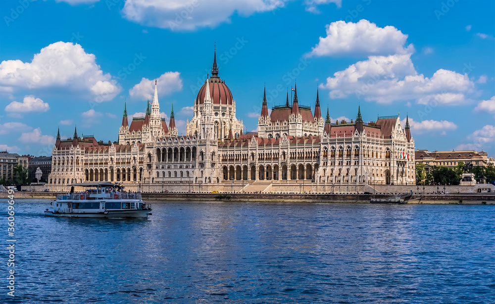 A view of the River Danube in Budapest towards the Parliament Building and river ferry during summertime A view of the River Danube in Budapest towards the Parliament Building and river ferry during summertime