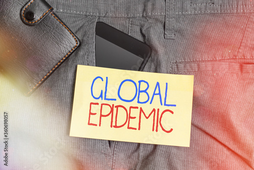 Word writing text Global Epidemic. Business photo showcasing a rapid spread of a communicable disease over a wide geographic area Smartphone device inside trousers front pocket with wallet and note photo