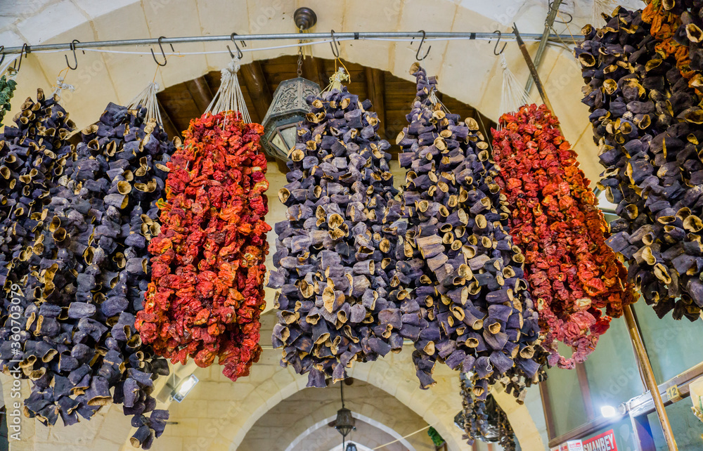 Hanged delicious colorful and sun dried marinated Turkish tomatoes, peppers and eggplants or aubergines in the traditional bazaar at Gaziantep City, Turkey. Dried tomatoes texture pattern background.	