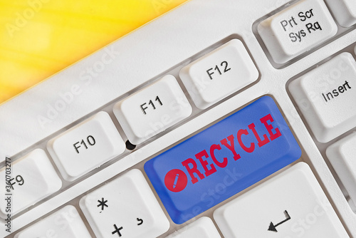 Conceptual hand writing showing Recycle. Concept meaning process of converting waste materials into new materials and objects White pc keyboard with note paper above white key copy space photo