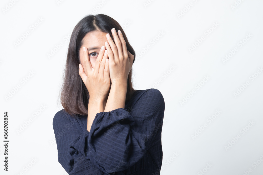 Beautiful young Asian woman peeking through fingers. Beautiful young Asian woman peeking through fingers.