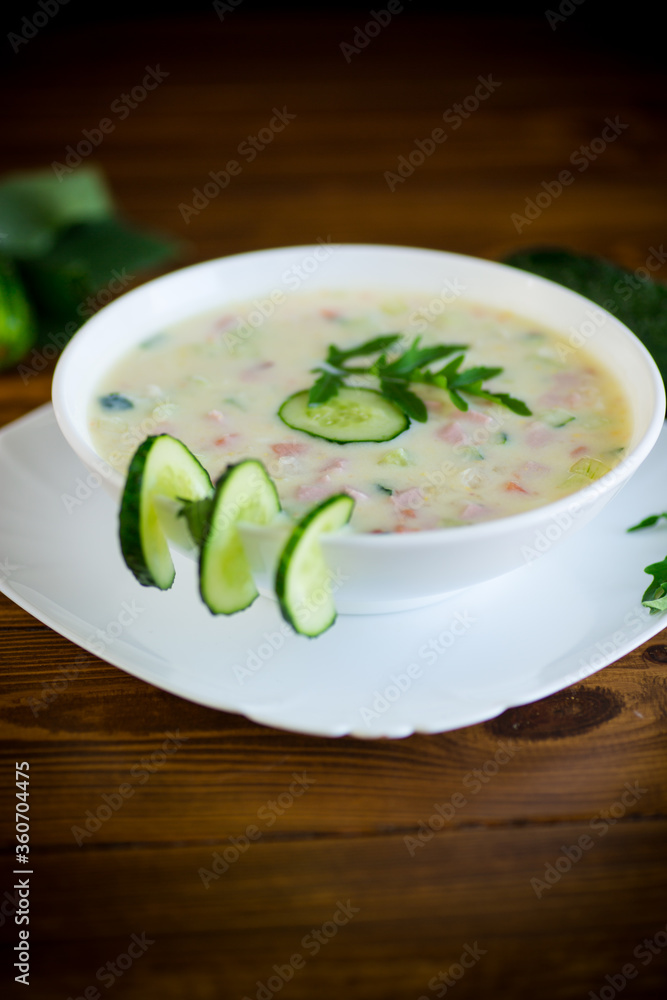 summer cucumber soup with vegetables on a wooden table summer cucumber soup with vegetables on a wooden table