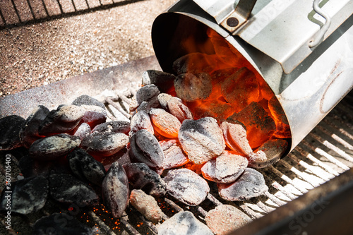 Glowing coals pouring from charcoal chimney starter