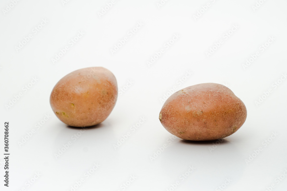 Two fresh potatoes isolated on white background with selective focus Two fresh potatoes isolated on white background with selective focus