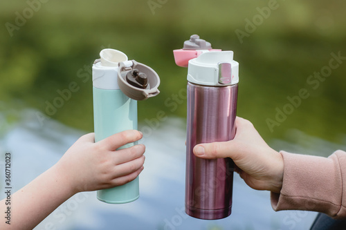 Concept of outdoor recreation using reusable dishes. A bottle for coffee or tea to go.