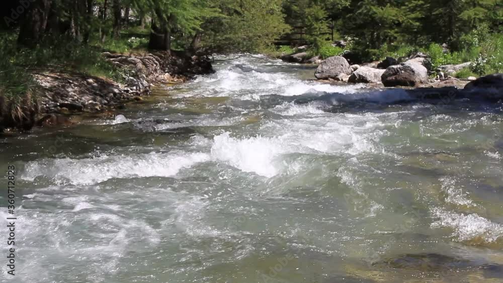 Waterfalls on a mountain river. Mountain river with abundant clear stream. Babbling creek with stone boulders flowing. Swift splashing water. Waterfalls on a mountain river. Mountain river with abundant clear stream. Babbling creek with stone boulders flowing. Swift splashing water.
