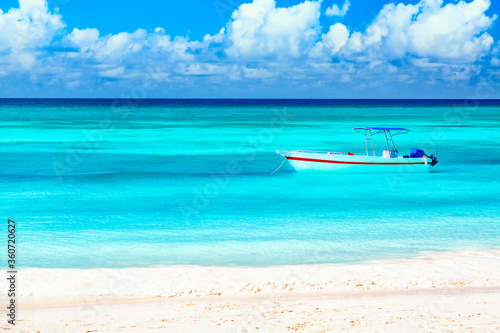 Boat and beautiful blue ocean and beach with white sand coast. Summer vacation travel background
