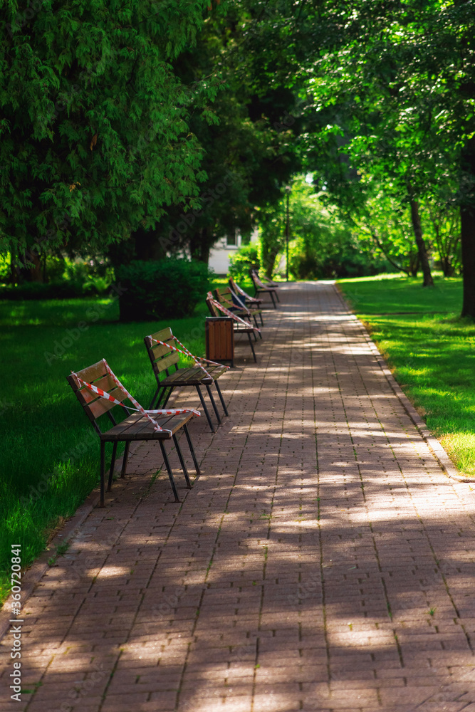 closed Park in Moscow, benches wrapped in red tape, no seats, quarantine, close-up. The concept of a ban on visiting public places. closed Park in Moscow, benches wrapped in red tape, no seats, quarantine, close-up. The concept of a ban on visiting public places.