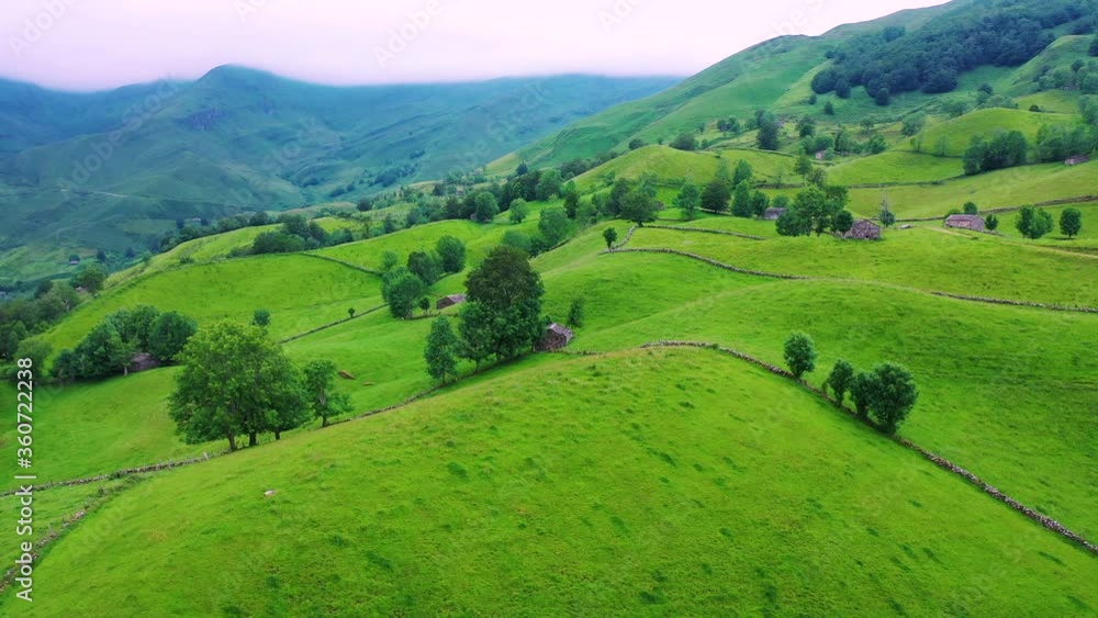 Aerial view with a drone of the spring landscape of pasiegas cabins and meadows in the Miera Valley in the Autonomous Community of Cantabria. Spain, Europe Aerial view with a drone of the spring landscape of pasiegas cabins and meadows in the Miera Valley in the Autonomous Community of Cantabria. Spain, Europe