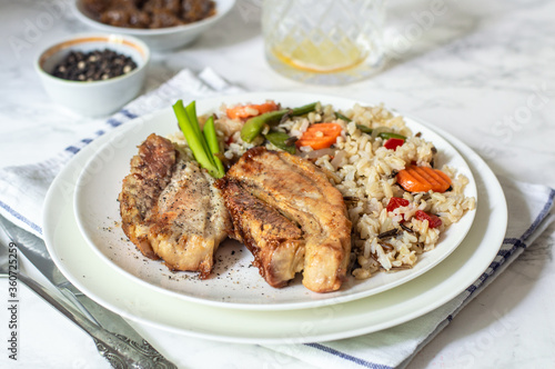 Baked pieces of pork with brown rice and vegetables
