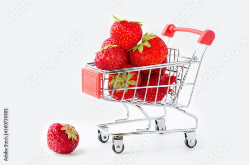 Tasty dessert. Strawberry in the buyer's basket. Gray isolated background.
