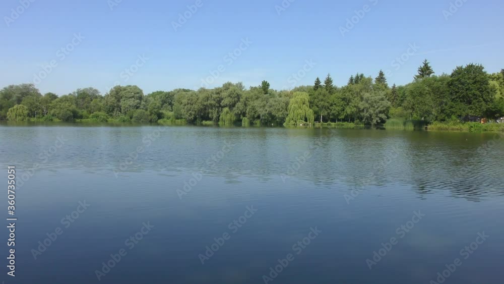 a small lake surrounded by trees in beautiful summer weather a small lake surrounded by trees in beautiful summer weather