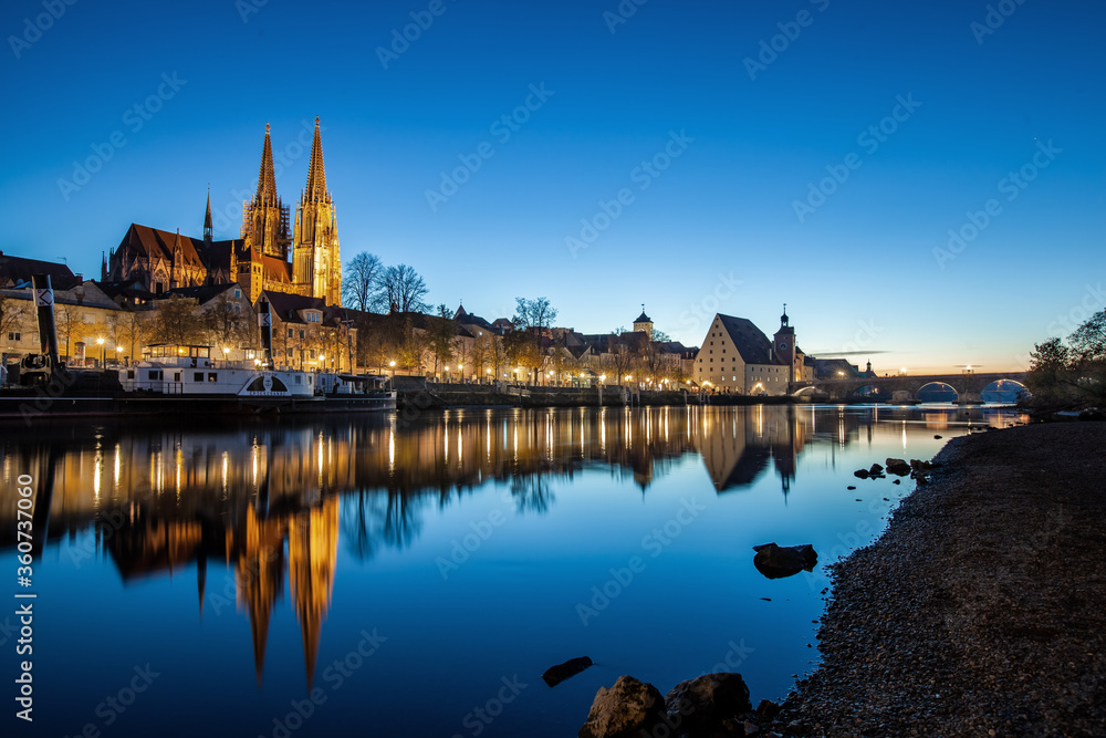 Fototapeta premium Regensburg mit spiegelung bei Niedrigwasser zur blauen Stunde