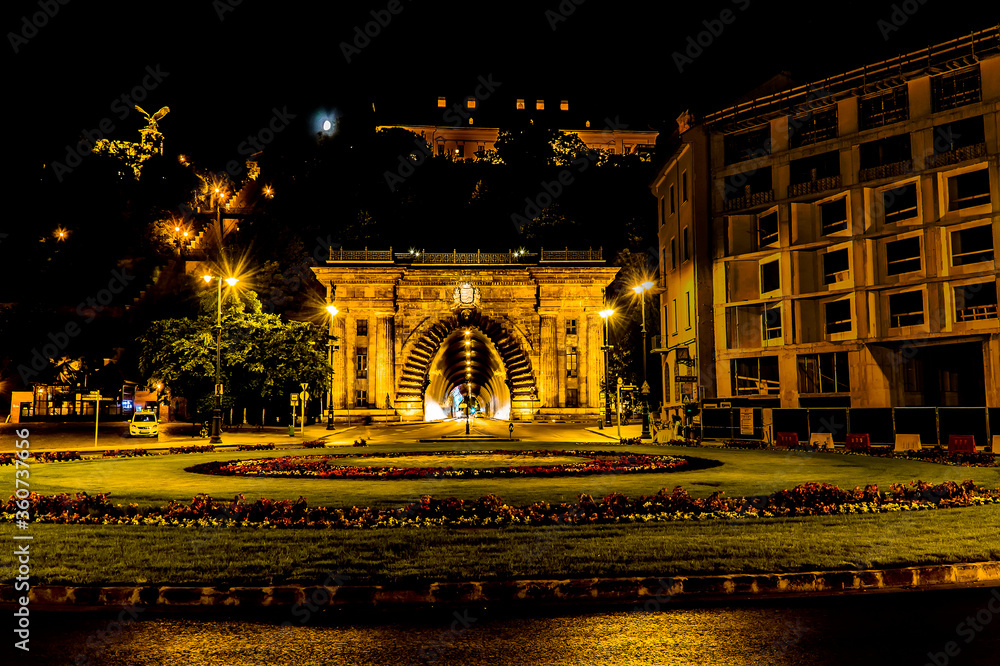 Fototapeta premium A view into the illuminated Buda Castle tunnel opposite the Chain Bridge in Budapest at night in the summertime