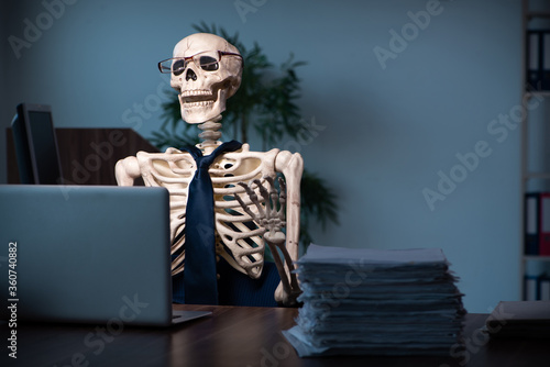 фотографія Young male employee working in the office night time