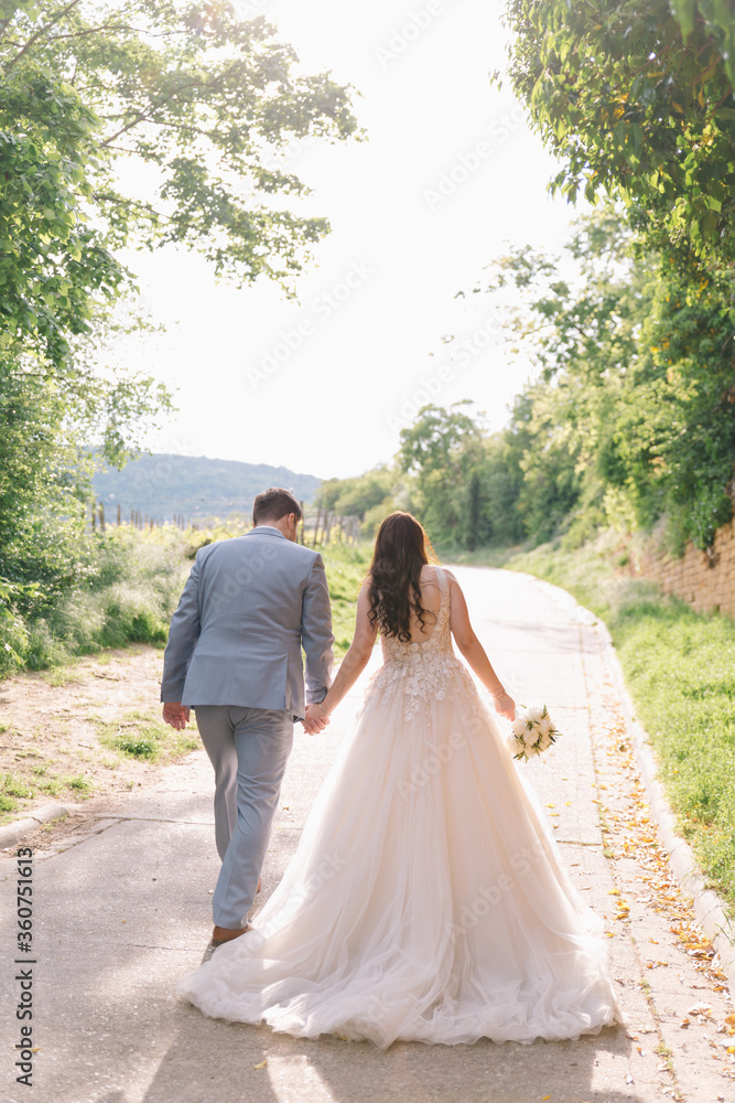 Hochzeit - Hochzeitsfotos von Braut und Bräutigam auf einem Feldweg in den pfälzer Weinbergen im Sommer - Langes weißes Hochzeitskleid mit Schleppe Hochzeit - Hochzeitsfotos von Braut und Bräutigam auf einem Feldweg in den pfälzer Weinbergen im Sommer - Langes weißes Hochzeitskleid mit Schleppe