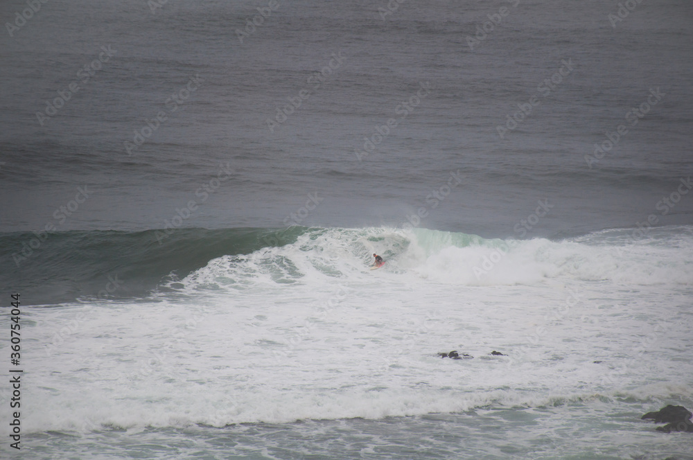 Obraz premium Man riding a barrel on a big swell at Honolua bay Maui