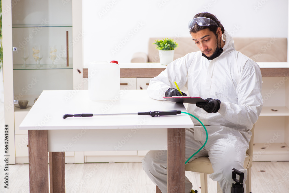 Young male contractor doing pest control at home Young male contractor doing pest control at home