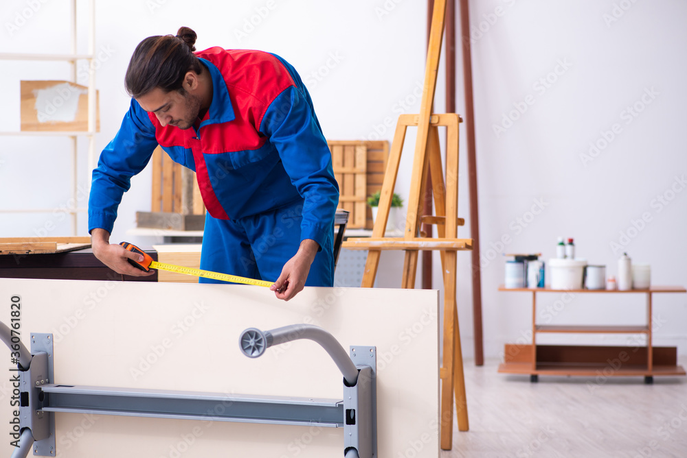 Young male contractor working in workshop Young male contractor working in workshop