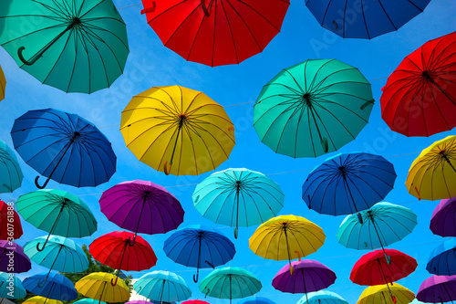 Colorful umbrellas in the sky. Sun and rain protection on the street.