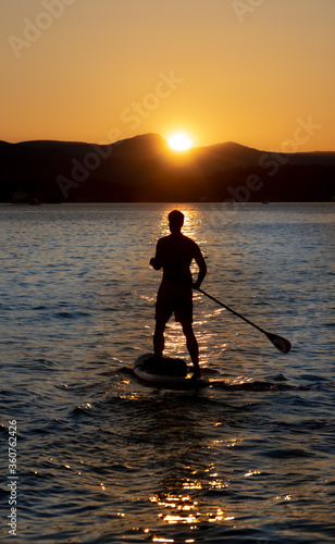 Man silhouette paddling in the sunset