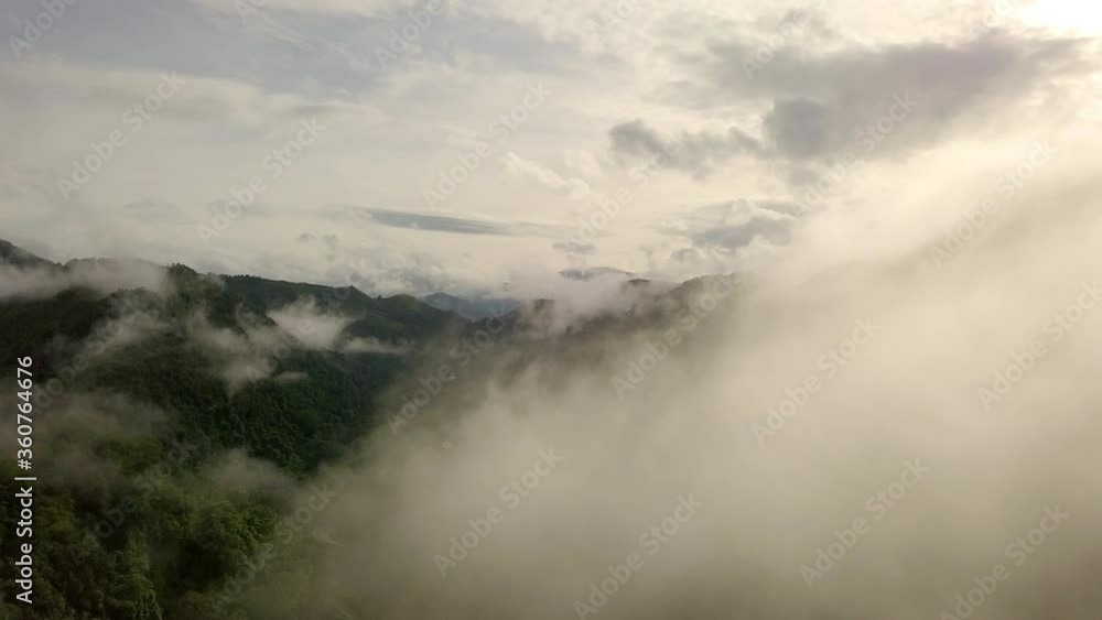 Aerial view flying thru the morning rain cloud covered tropical rain forest mountain landscape during the rainy season on the Doi Phuka Mountain reserved national park the northern Thailand Aerial view flying thru the morning rain cloud covered tropical rain forest mountain landscape during the rainy season on the Doi Phuka Mountain reserved national park the northern Thailand