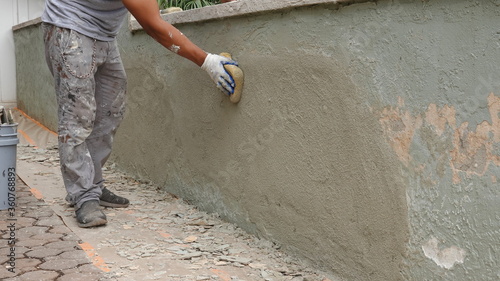 Φωτογραφία Medium shot of handyman smoothing the texture on a repaired stucco wall