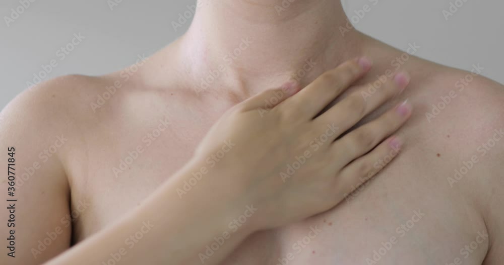 Woman is applying moisturizing cream on her chest and shoulders, closeup front view. Body care, skin care, wellness, cosmetic, beauty and spa procedures. Part of naked body. Woman is applying moisturizing cream on her chest and shoulders, closeup front view. Body care, skin care, wellness, cosmetic, beauty and spa procedures. Part of naked body.