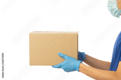 Delivery man hand in medical gloves and wearing mask holding cardboard boxes isolated on white background, Delivery service concept. © Touchr