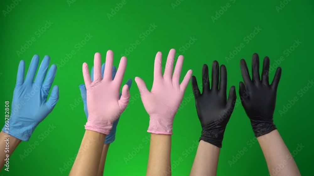 Hands in medical gloves up isolated on a green background. Protest movement, greeting, fans. Period of the coronavirus pandemic Hands in medical gloves up isolated on a green background. Protest movement, greeting, fans. Period of the coronavirus pandemic