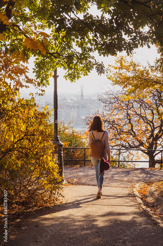 Canvas Print Beautiful woman walking in autumn park on Buda Castle on banks of Danube in Budapest, Hungary