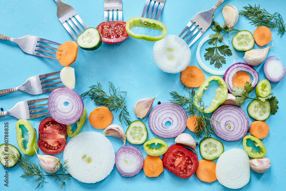 Onion rings on blue background. Fresh organic onion, garlic and bell pepper, celery, dill vegetables with copy space. Vegetarian background Onion rings on blue background. Fresh organic onion, garlic and bell pepper, celery, dill vegetables with copy space. Vegetarian background