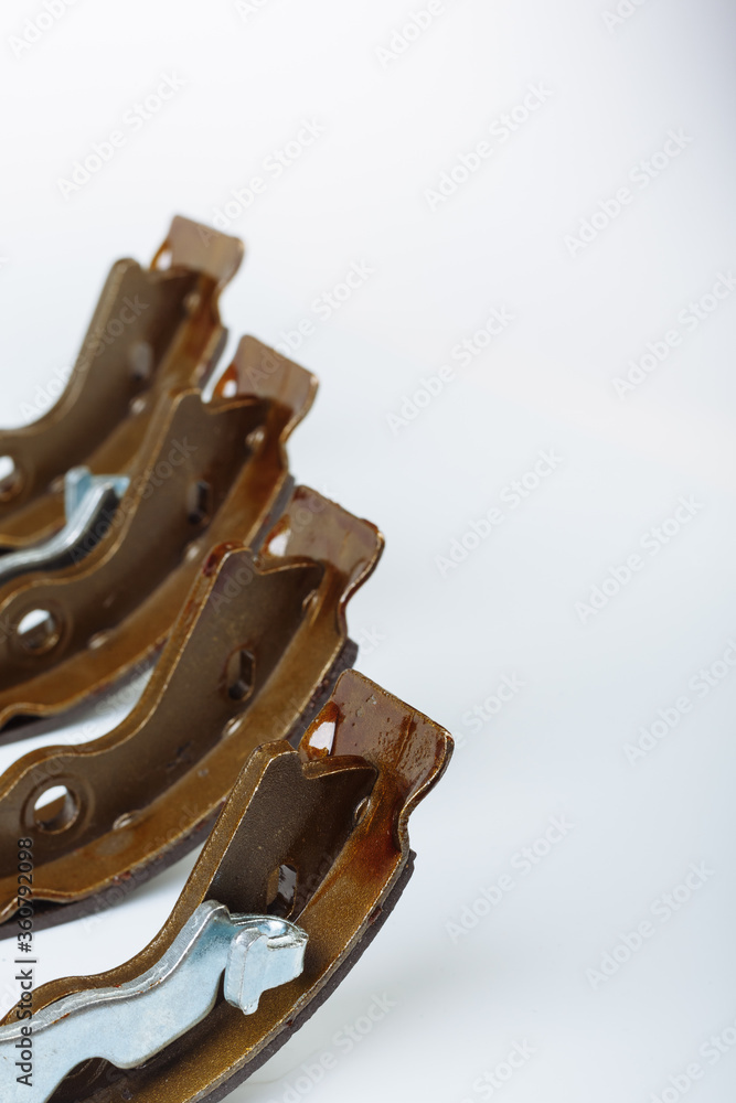 Obraz premium A couple of hand drum brake pads are lying on the white surface before replacement operation