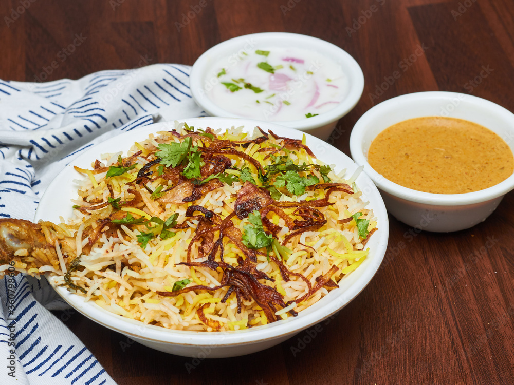 Chicken Biryani is a savory chicken and rice dish that includes layers of chicken, rice, and aromatics that are steamed together. Chicken Biryani is a savory chicken and rice dish that includes layers of chicken, rice, and aromatics that are steamed together.