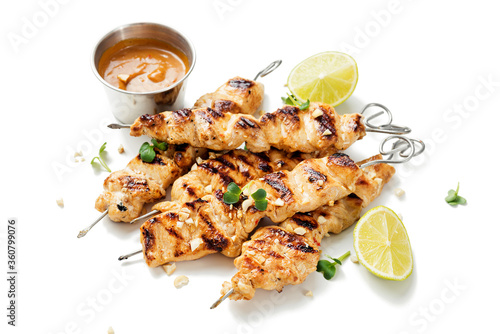 Grilled chicken satay skewers with peanut butter sauce isolated on white background