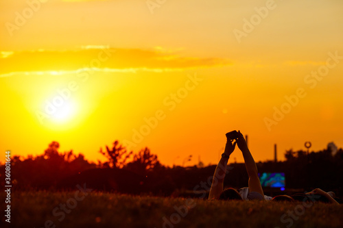 Girls take selfies lying on the background of the sunset