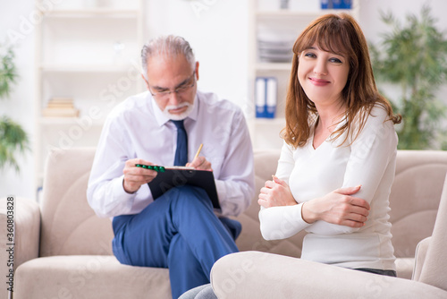 Young woman visiting old male doctor psychologist