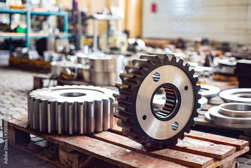 Konstfotografi Two large gears after heat treatment lie on a wooden rack