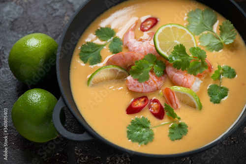 Thai-style soup with prawns, pumpkin, coconut milk, red chili, lime and coriander, selective focus, studio shot
