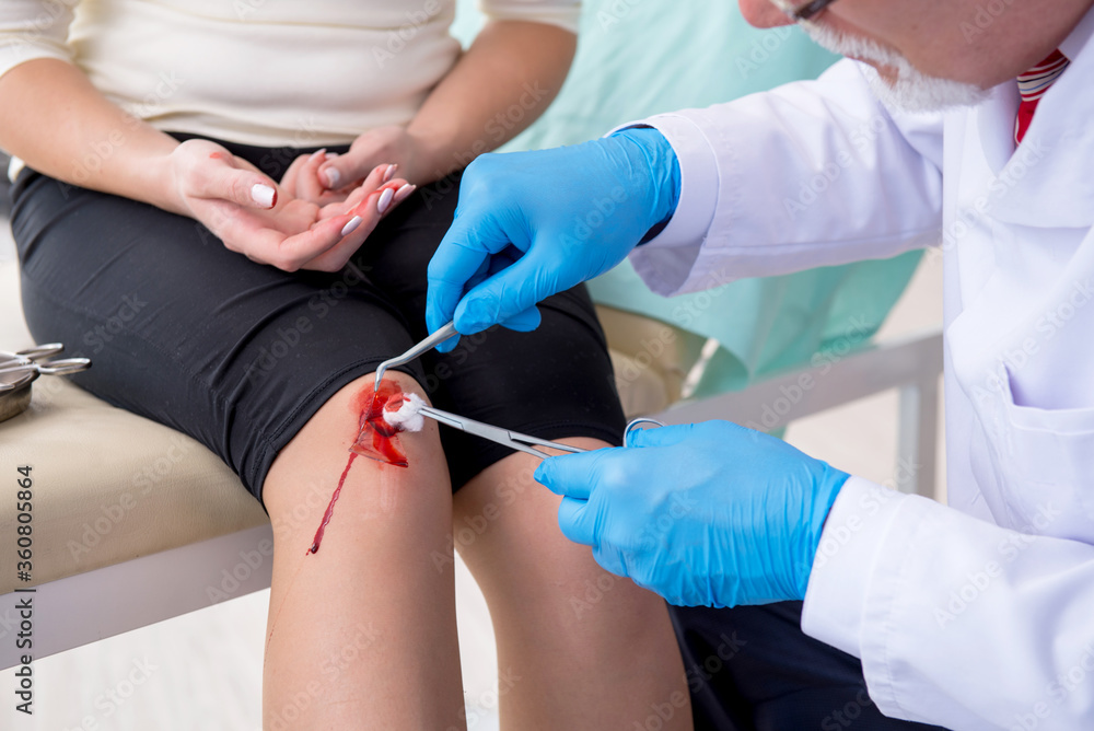 Leg injured woman visiting male doctor Leg injured woman visiting male doctor
