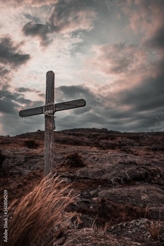 Vertical image of a wooden cross on the rocky mountains of Mallin in Cordoba, Argentina photo