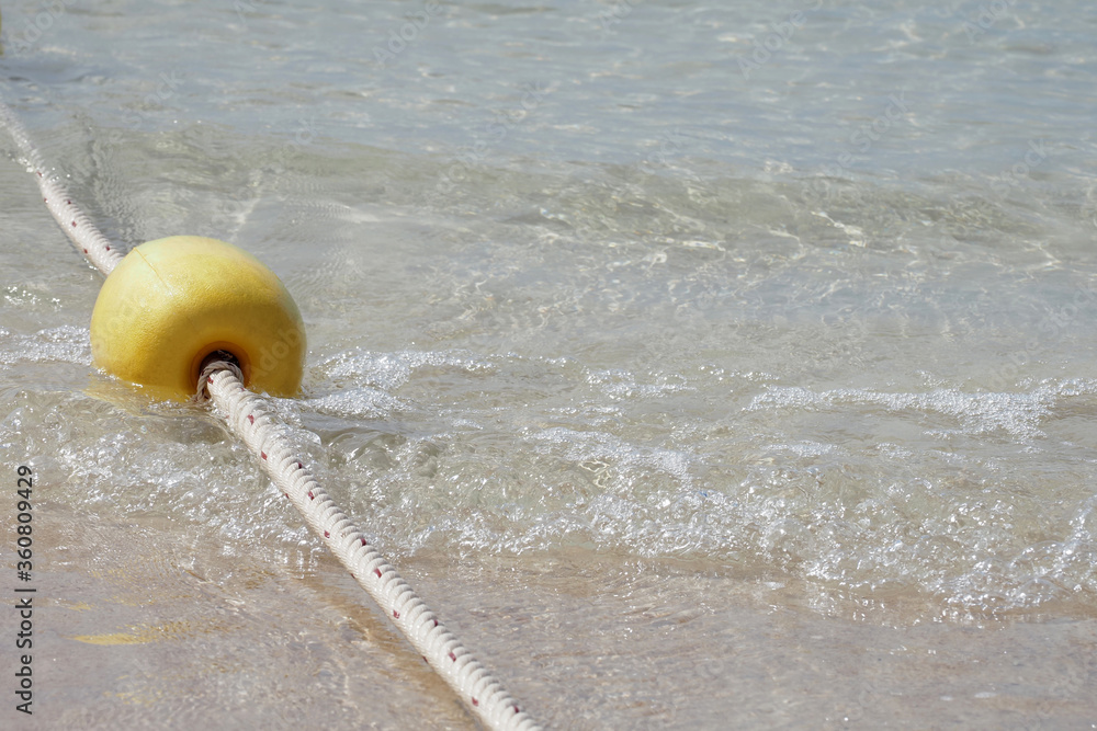 Naklejka premium Yellow buoy is a channel buoy in the sea with rope boundary line To be a swimming area for tourists