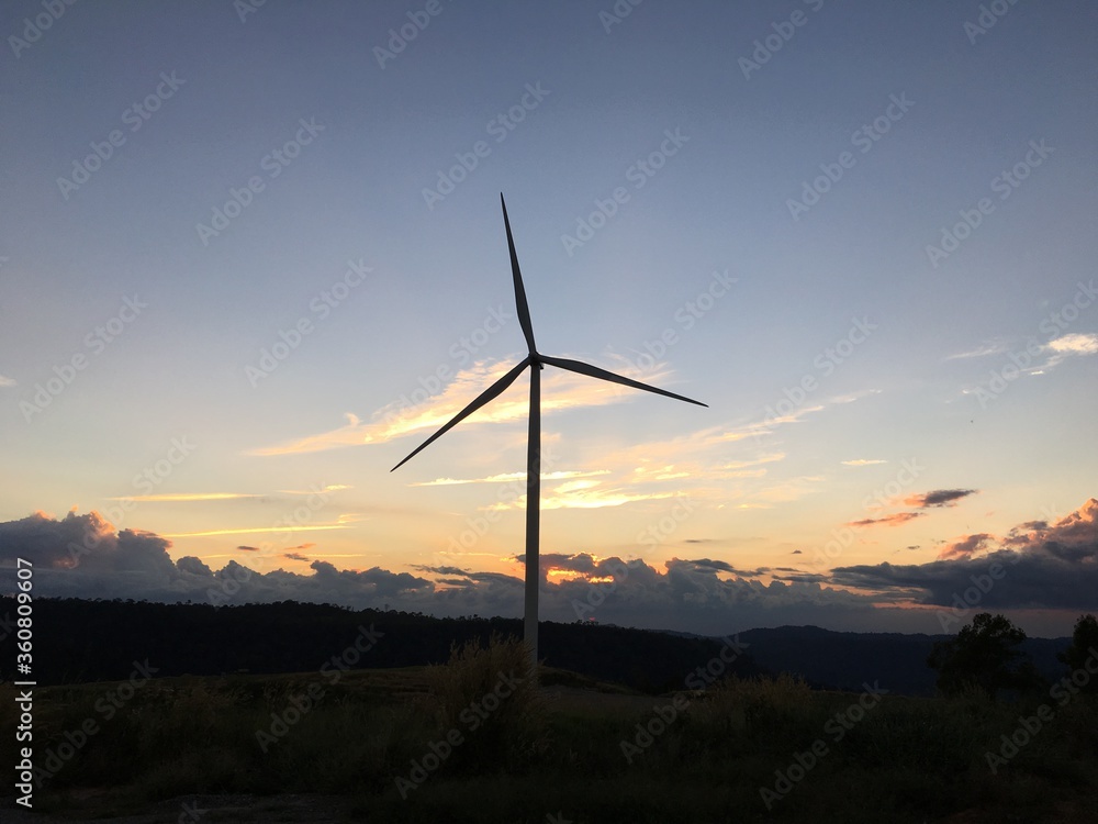 Windmills On Field Against Sky At Sunrise
