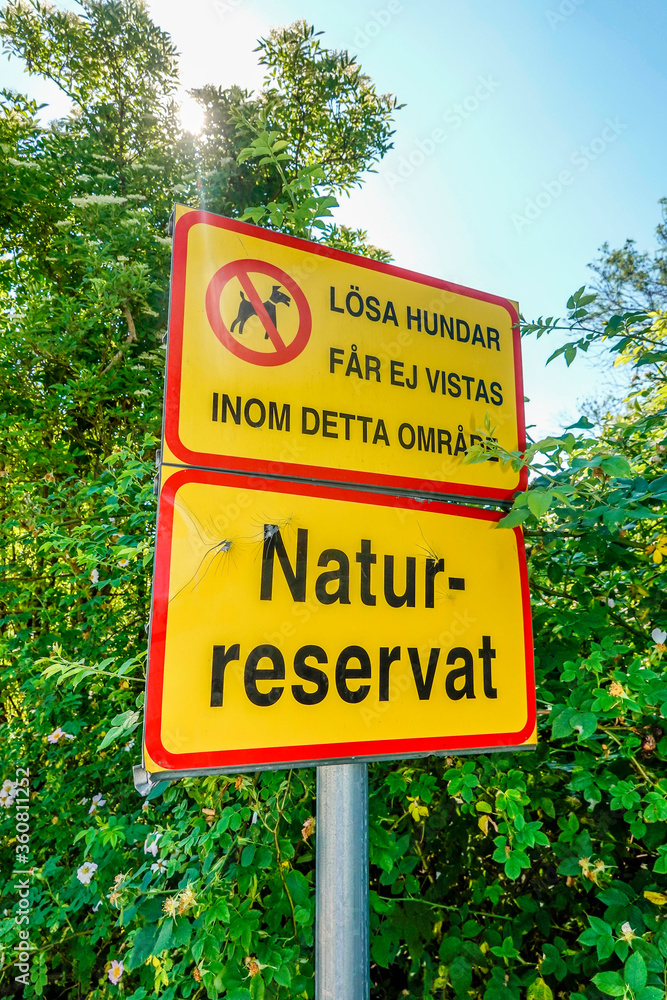 Stockholm, Sweden June 29, 2020 A sign in a park says Nature Reserve in Swedish and that dogs should leashed.